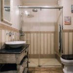 Reforma integral baño con parquet y pared con papel