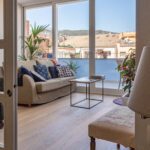 Un salón con grandes ventanales y salida a l'exterior